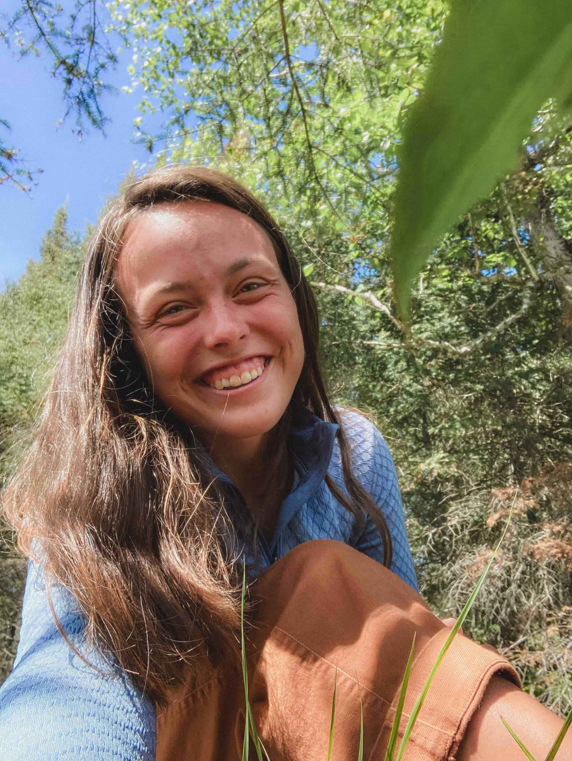 Bright smiling woman outdoors in nature, promoting Coldwater Foundation's 2025 initiatives and environmental impact.