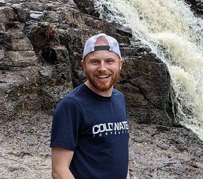 Clean water advocate at Coldwater Foundation volunteering near waterfall.